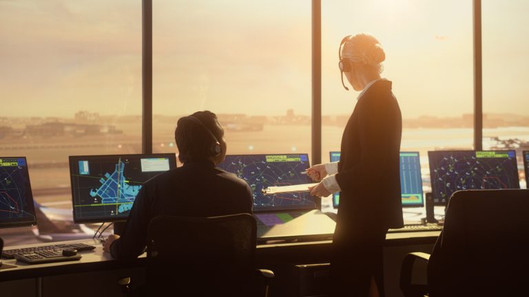 Air Traffic Control Team Working in Modern Airport Tower at Sunset. For slot scheduling blog.
