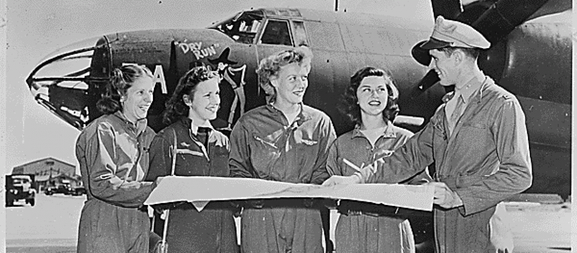 Four members of the United States Women's Airforce Service Pilots (WASPs) receive final instructions as they chart a cross-country course on the flight line of U.S. airport. (National Archives)