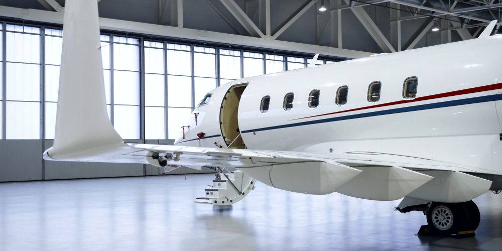Luxury business jet airplane being stored inside an aviation hangar
