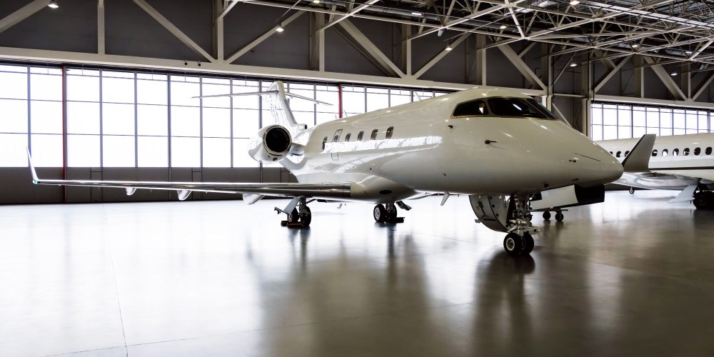 Luxury business jet airplanes being stored inside an aviation hangar