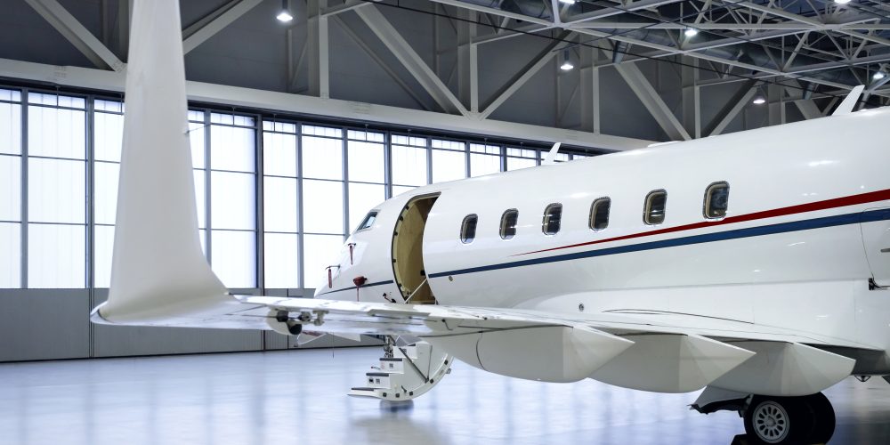 Luxury business jet airplane being stored inside an aviation hangar