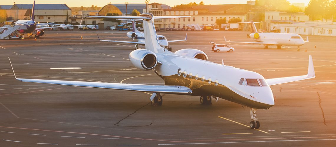 Private jet aircraft at airport. Illuminated by the sun at sunset. Top and side view.
