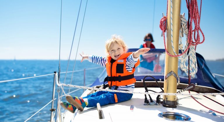 Kids sail on yacht in sea.