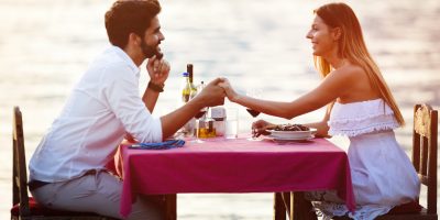 Young couple have romantic evening dinner on sea beach
