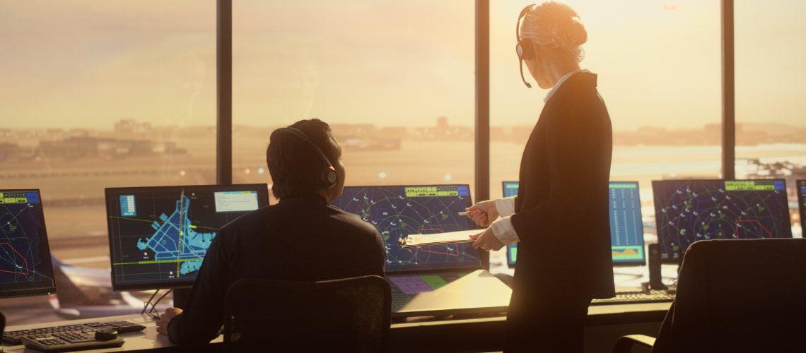 Air Traffic Control Team Working in Modern Airport Tower at Sunset. For slot scheduling blog.